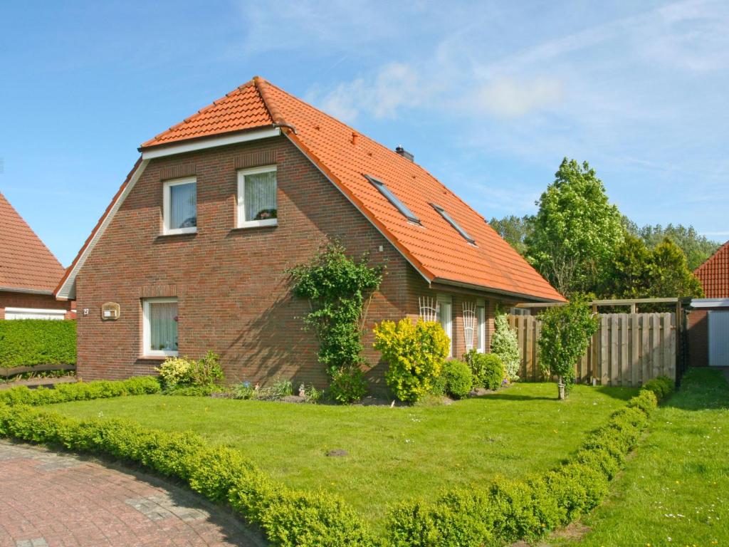 a brick house with an orange roof at Apartment Schonerweg by Interhome in Norddeich