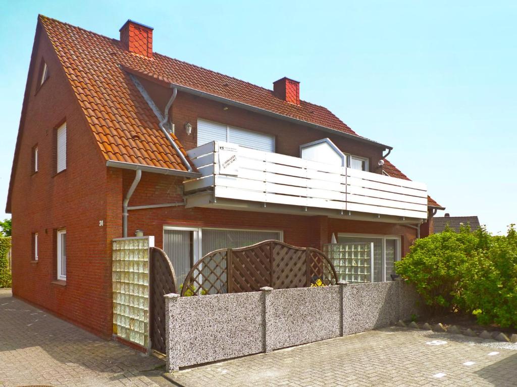 a red brick house with a balcony on it at Apartment Am Koper Sand-1 by Interhome in Norddeich