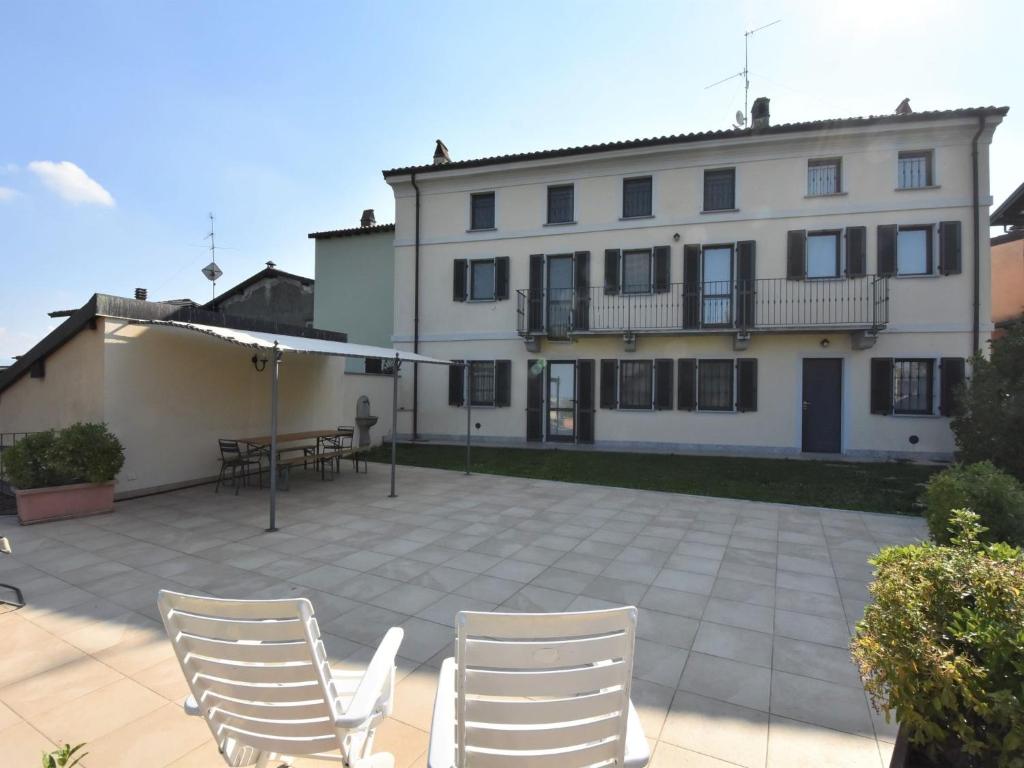 een gebouw met witte stoelen en een patio bij Holiday Home La Corte Bricca - Casa Padronale by Interhome in Castana