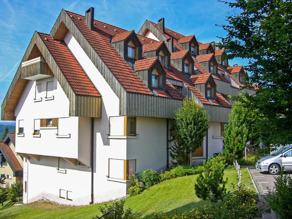 uma casa com um telhado vermelho numa colina em Apartment Schwarzwaldblick-13 by Interhome em Obertal
