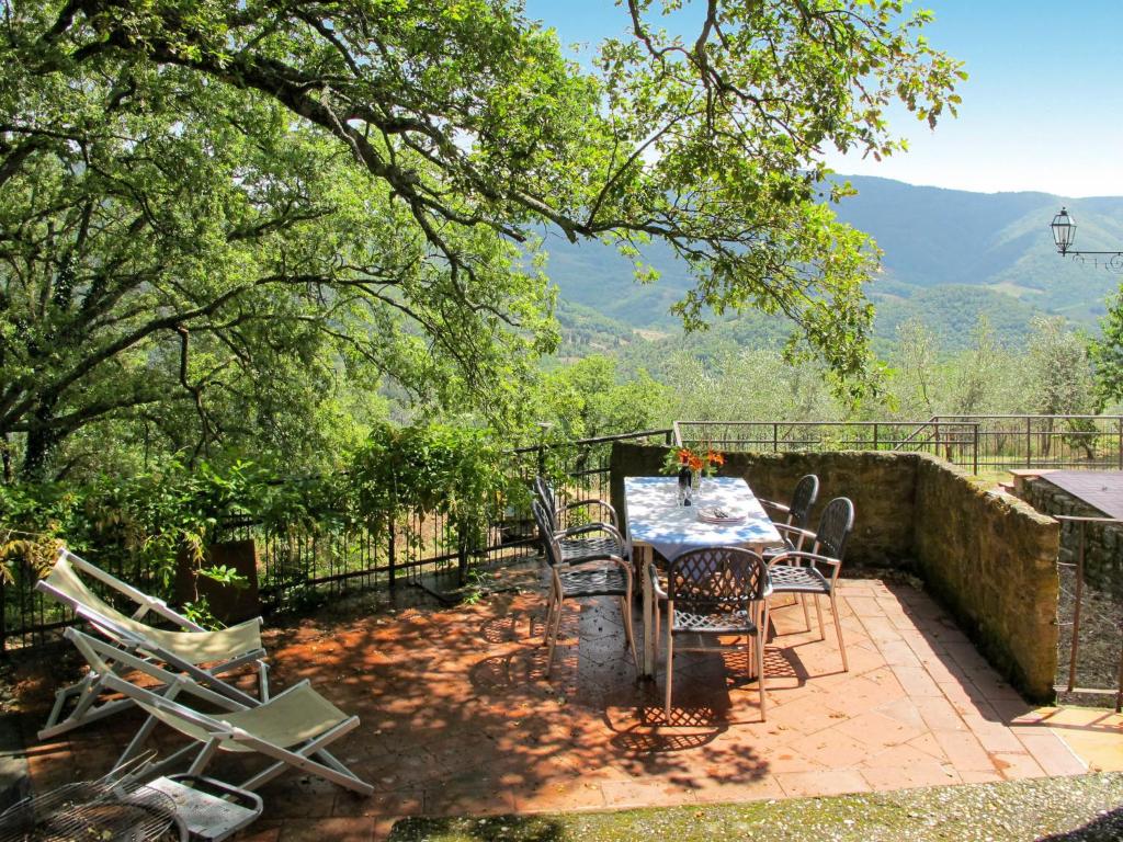 een tafel en stoelen op een patio met bergen op de achtergrond bij Holiday Home Capella by Interhome in Linari