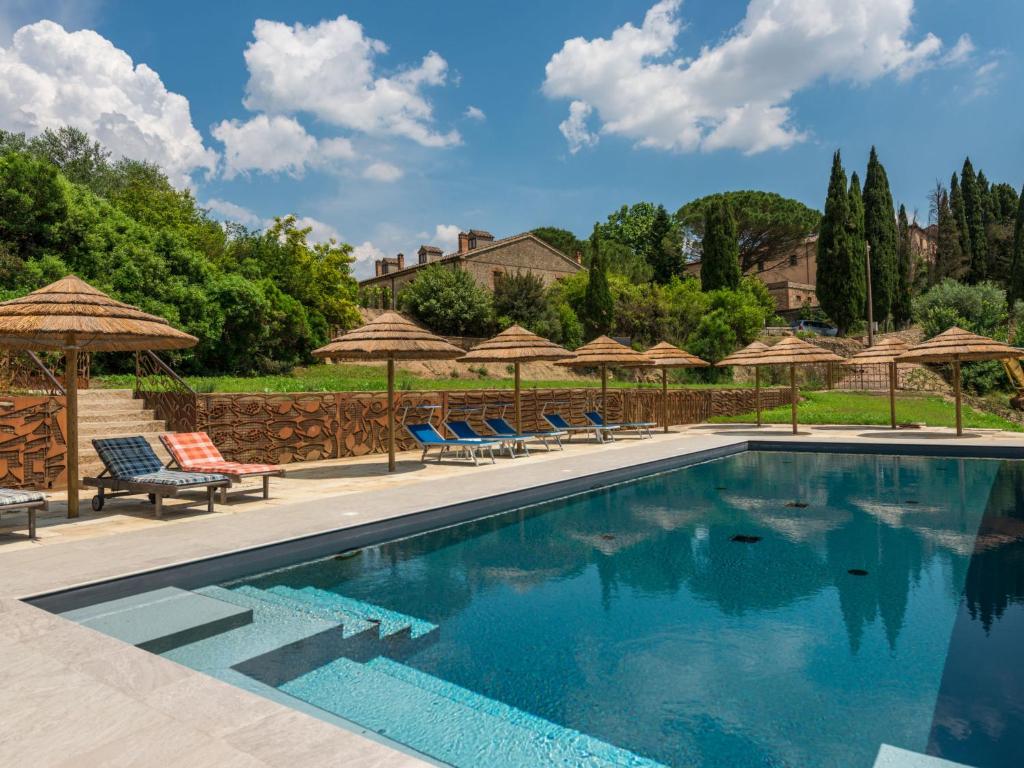 a swimming pool with chairs and umbrellas at Apartment Violapo al Castello by Interhome in Monte Antico