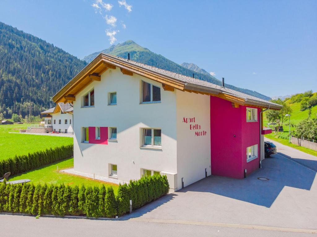 ein Haus mit rot-weißer Farbe in der Unterkunft Apartment Bella Monte-2 by Interhome in Pettneu am Arlberg