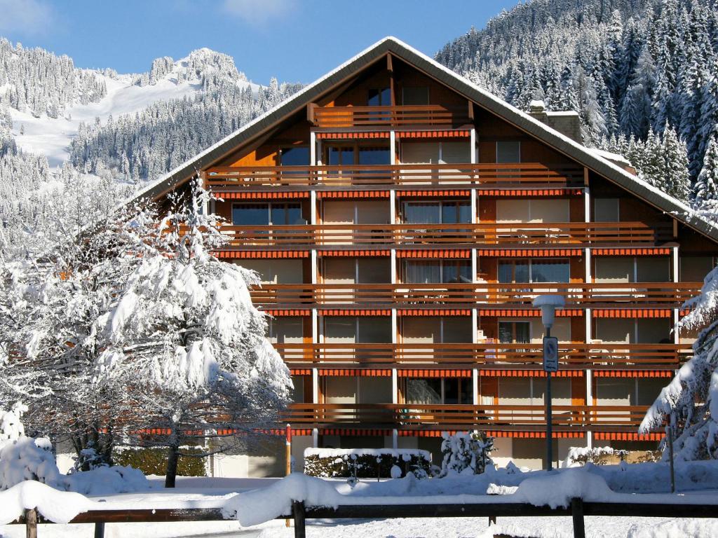 a large wooden building with snow on the ground at Apartment Grenat 35 by Interhome in Villars-sur-Ollon
