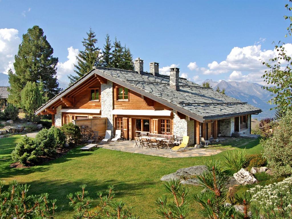 a log house with a patio and a yard at Holiday Home Les Clèves by Interhome in Nendaz
