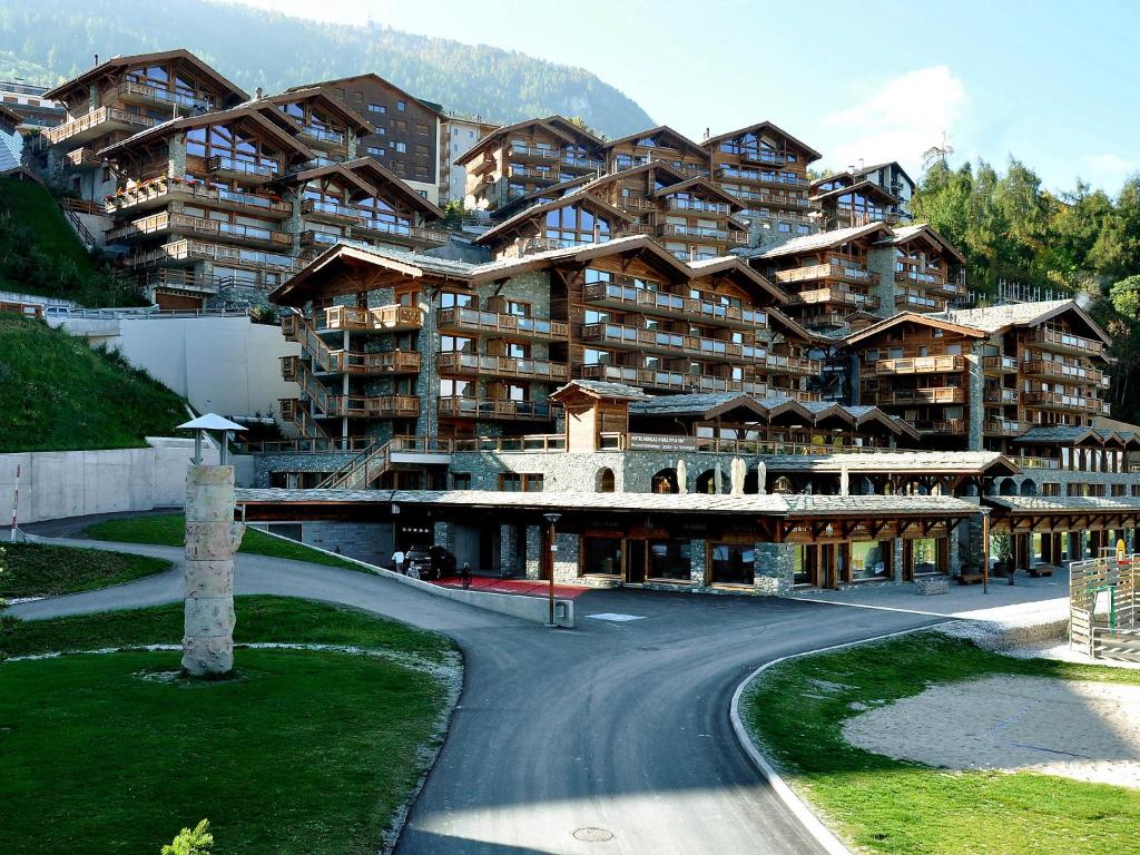 a large building with a road in front of it at Apartment Montagnard 10 by Interhome in Nendaz