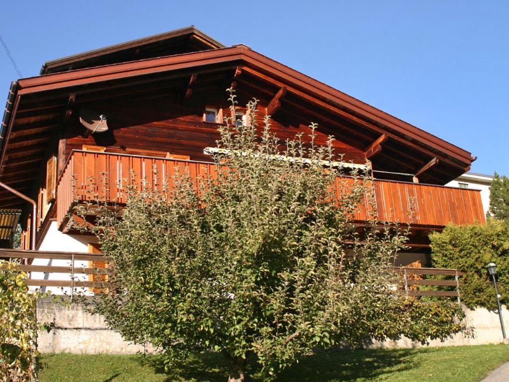 a wooden house with a balcony on the side of it at Holiday Home Chalet Ahornen by Interhome in Grindelwald