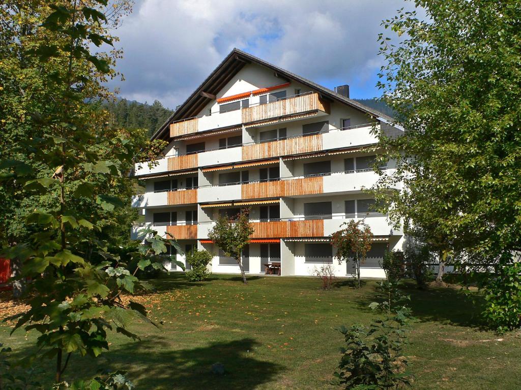 a large apartment building with a lawn in front of it at Apartment Val Signina-1 by Interhome in Laax-Murschetg