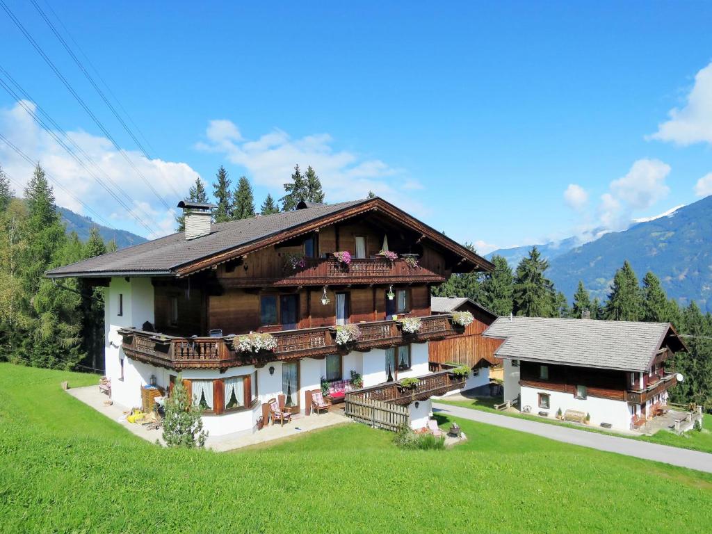 a large house in a field with mountains in the background at Apartment Luxner - KAB137 by Interhome in Kaltenbach