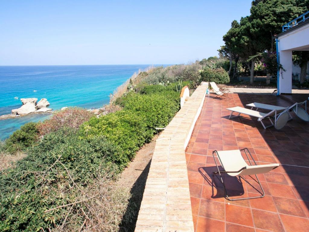 a patio with chairs and a view of the ocean at Apartment Sulla Scogliera by Interhome in Santa Domenica