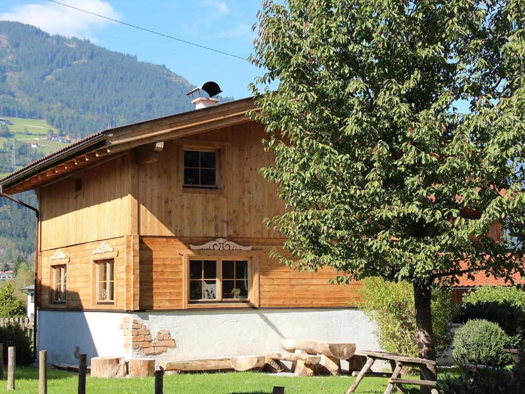 ein Holzhaus mit einem Baum davor in der Unterkunft Holiday Home Alpendorf-2 by Interhome in Stumm
