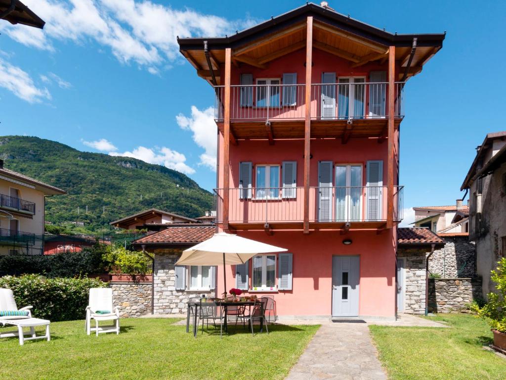 een rood gebouw met een tafel en een paraplu bij Holiday Home Ribes by Interhome in Consiglio di Rumo