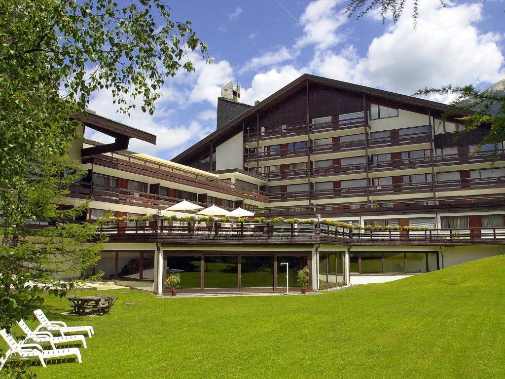 un grand bâtiment avec une pelouse devant lui dans l'établissement Apartment Birkenwald-3 by Interhome, à Seefeld in Tirol