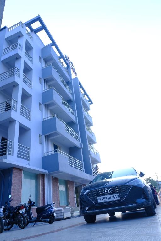 a car parked in front of a building at Hotel Girija Sunrise in Deoghar