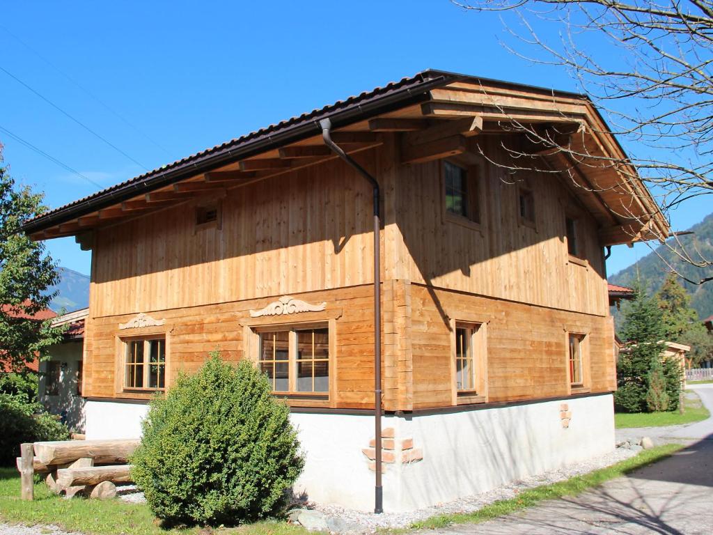 een houten huis met een gambrel dak bij Holiday Home Alpendorf-3 by Interhome in Gattererberg