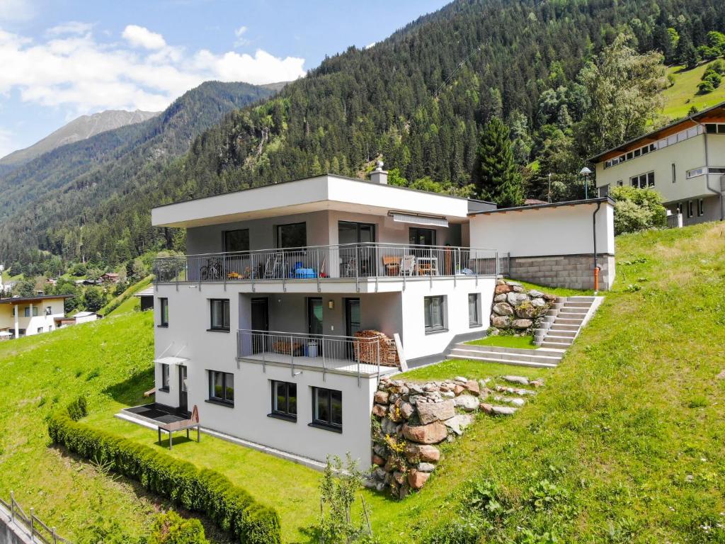 una casa bianca su una collina con montagne sullo sfondo di Apartment Collina by Interhome a See