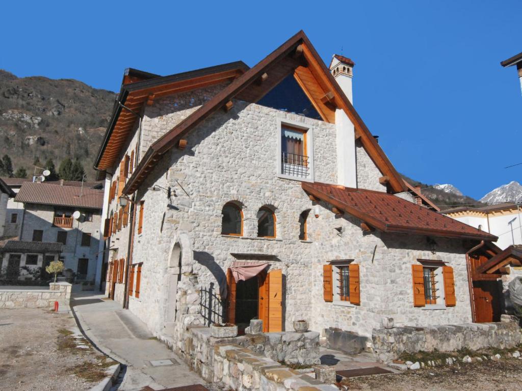 un antiguo edificio de piedra con techo marrón en Apartment Albergo Diffuso - Cjasa Ustin-2 by Interhome, en Barcis