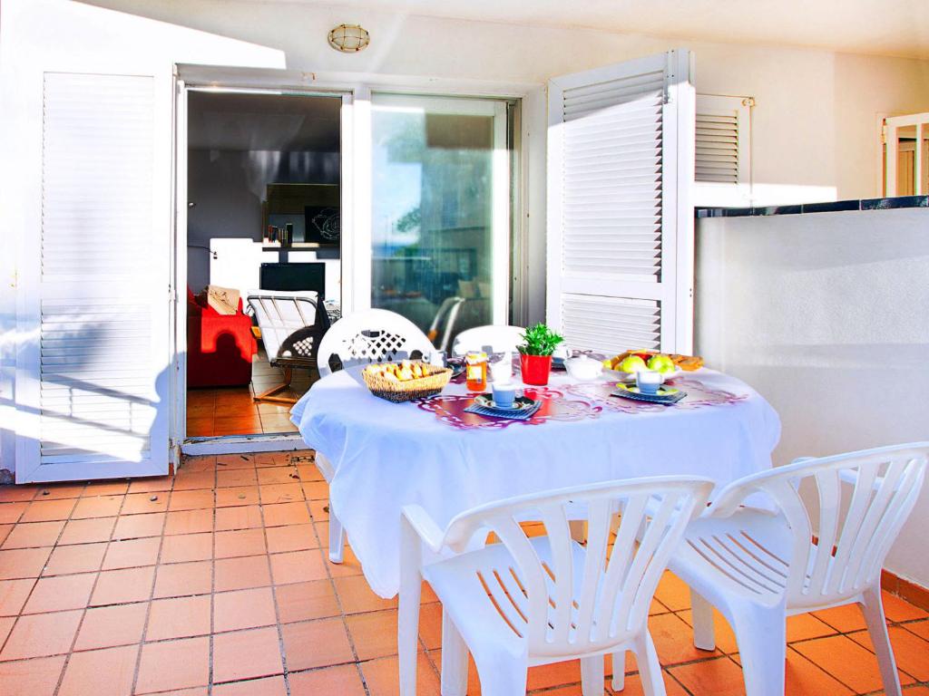 einen weißen Tisch mit weißen Stühlen in einem Zimmer in der Unterkunft Apartment Platja de Roses-1 by Interhome in Roses