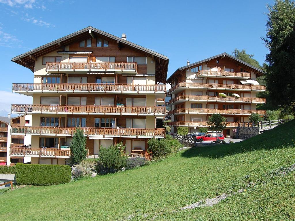 a large apartment building on top of a hill at Apartment Ambassador I Apt 7 by Interhome in Nendaz
