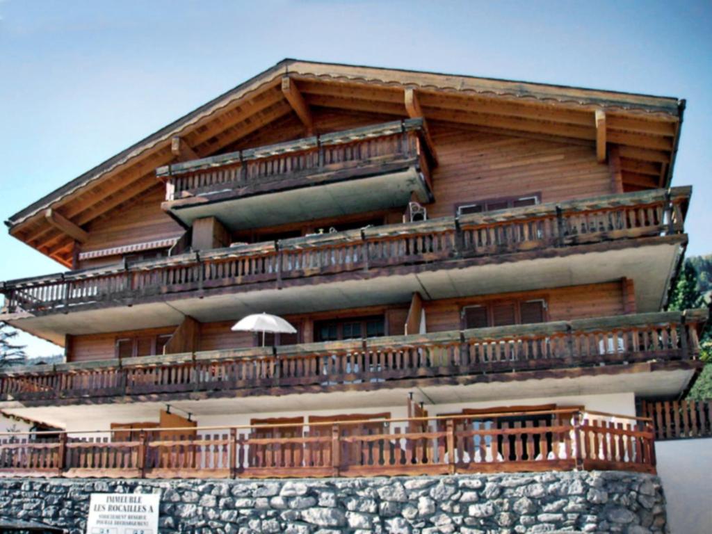 a building with a large balcony on top of it at Apartment Les Rocailles by Interhome in Anzère