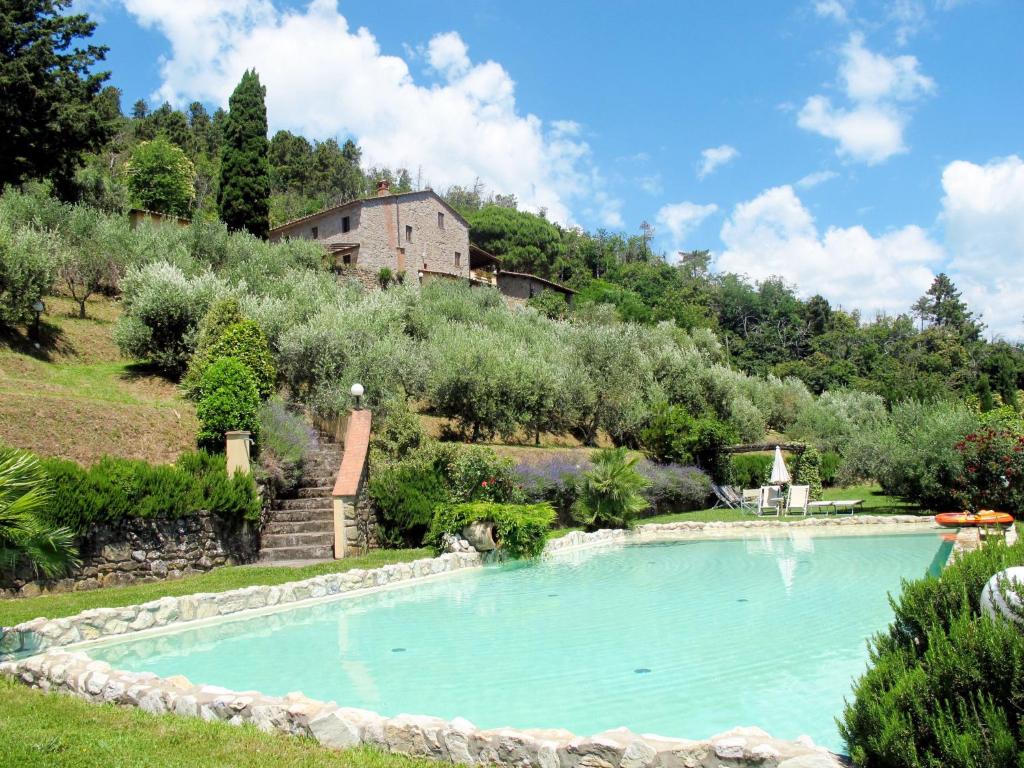 una piscina in un giardino con una casa sullo sfondo di Holiday Home La Cupola- Giglio by Interhome a Pescia