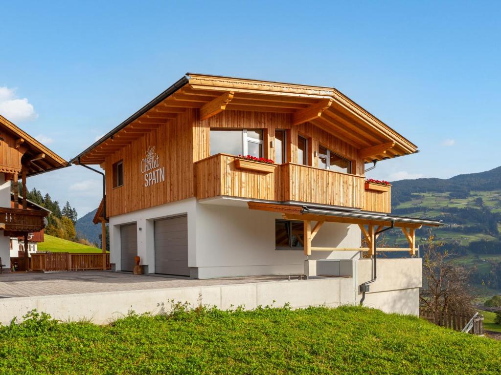 uma casa com uma varanda no topo de uma colina em Apartment Chalet Spatn by Interhome em Fügenberg