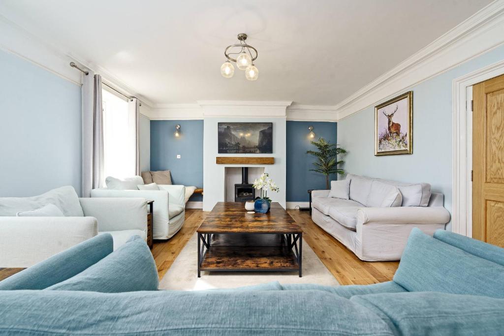 - un salon avec des murs bleus et un mobilier blanc dans l'établissement Clovelly House Beautiful 5 bedroom, 5 bathroom home, à Berwick-upon-Tweed