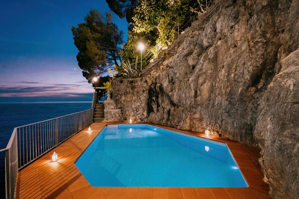 ein Pool vor einer Felswand in der Unterkunft Villa Eris Amalfi Coast in Conca dei Marini