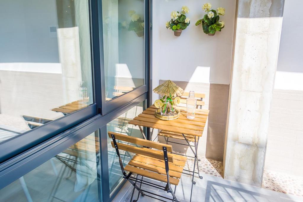 d'un balcon avec une table et une chaise en bois. dans l'établissement SW Jara Centro Apartamento Boutique, à Malaga