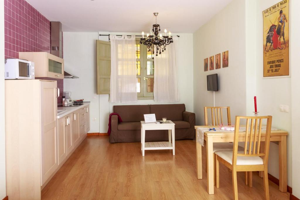 a kitchen and a living room with a couch and a table at La Casita de Hinestrosa in Málaga