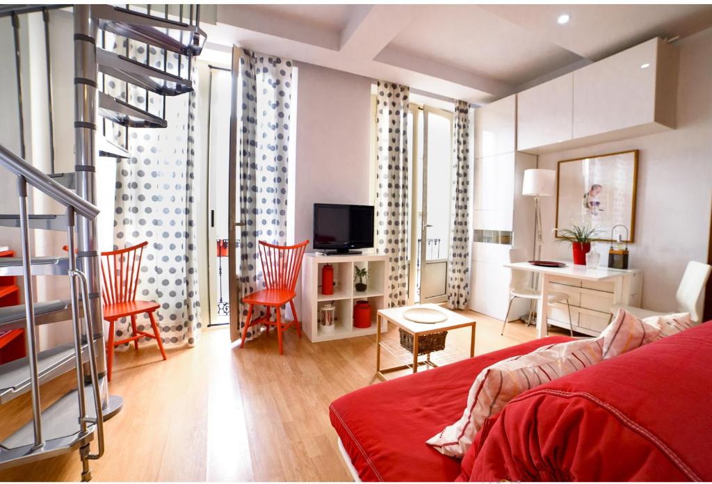 マラガにあるSW Charming Duplexのリビングルーム(赤いソファ付)、テーブルが備わる客室です。