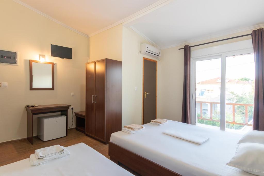 um quarto com duas camas e uma janela em Myrodato Rooms em Xanthi