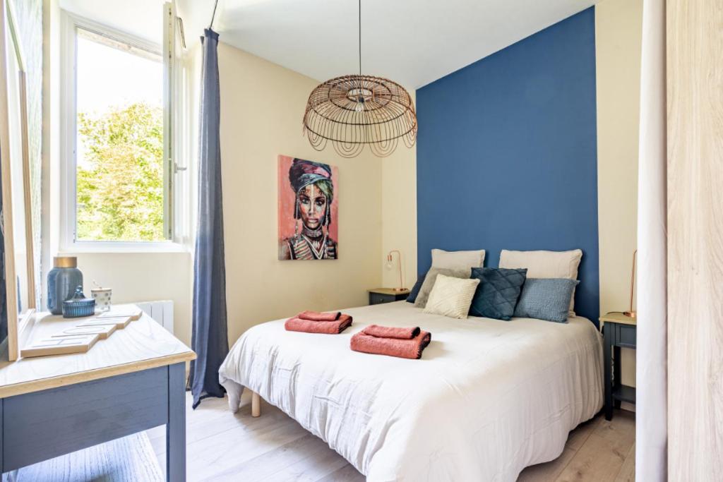 - une chambre avec un grand lit blanc et un mur bleu dans l'établissement Le Belleville, proche hypercentre au calme, wifi, à Nantes