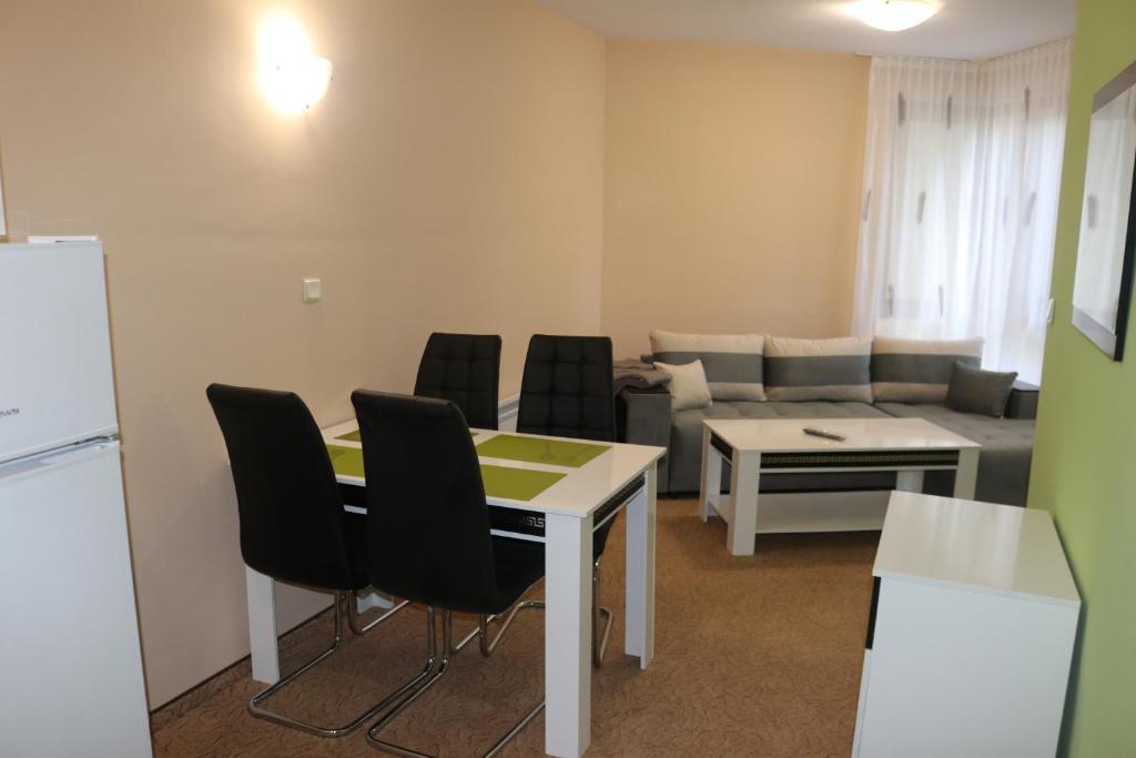 sala de estar con mesa, sillas y sofá en Winter Аpartments Gerovi en Pamporovo