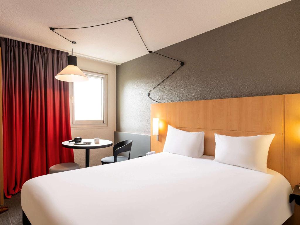 A bed or beds in a room at ibis Cergy Pontoise Le Port