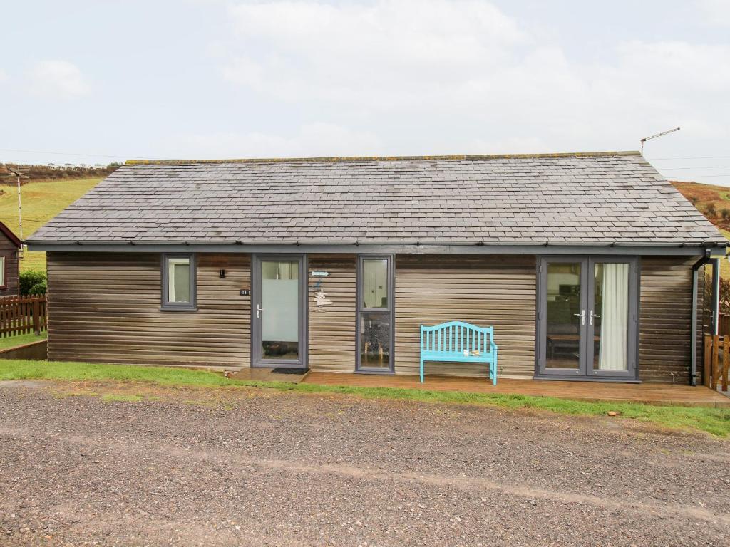 een huis met een blauwe bank ervoor bij Beside the Sea in Bridport