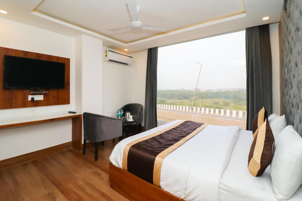 ein Hotelzimmer mit einem Bett und einem großen Fenster in der Unterkunft Hotel View - A Boutique Hotel in Neu-Delhi
