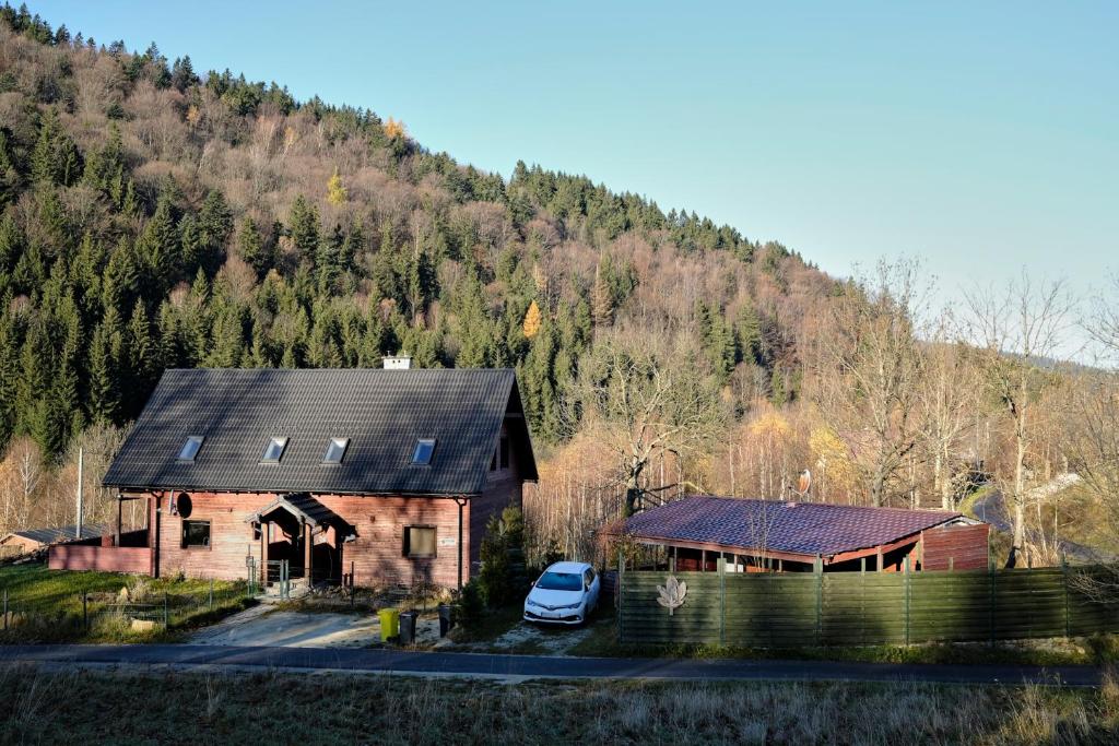 a house with a car parked in front of a mountain at Królikówka in Stronie Śląskie