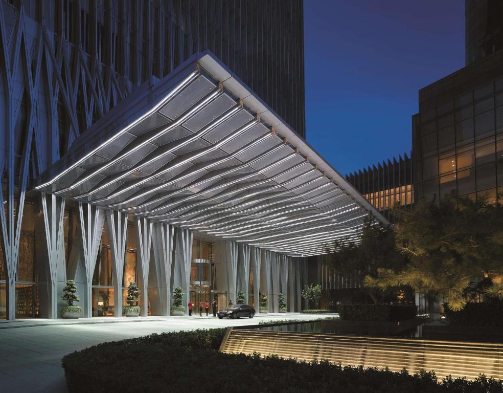 a building with a lit up canopy in front of it at China World Summit Wing, Beijing in Beijing