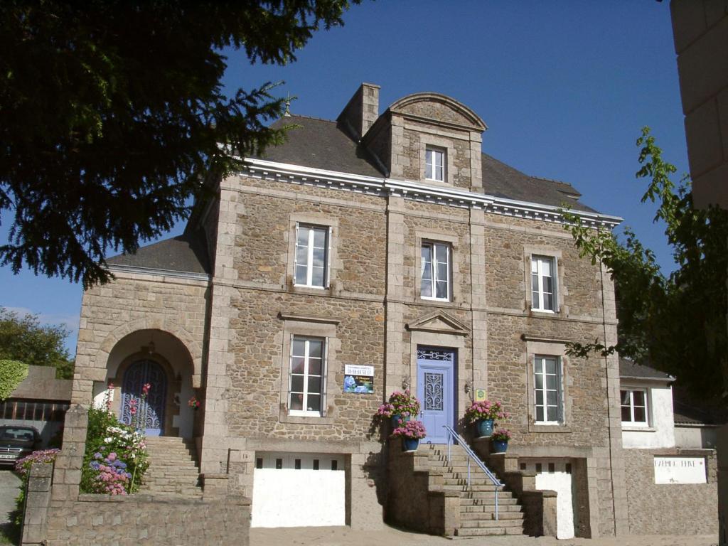 Un grand bâtiment en briques avec des escaliers se trouve juste devant. dans l'établissement La Demeure aux Hortensias, à Pleurtuit