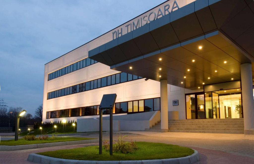 a building with a sign in front of it at NH Timisoara in Timişoara