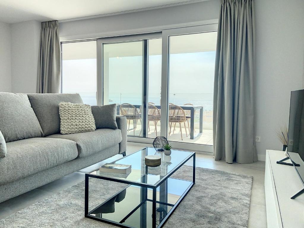 salon z kanapą i szklanym stołem w obiekcie Via Celere 2330 Sea View Apartment w mieście Casares