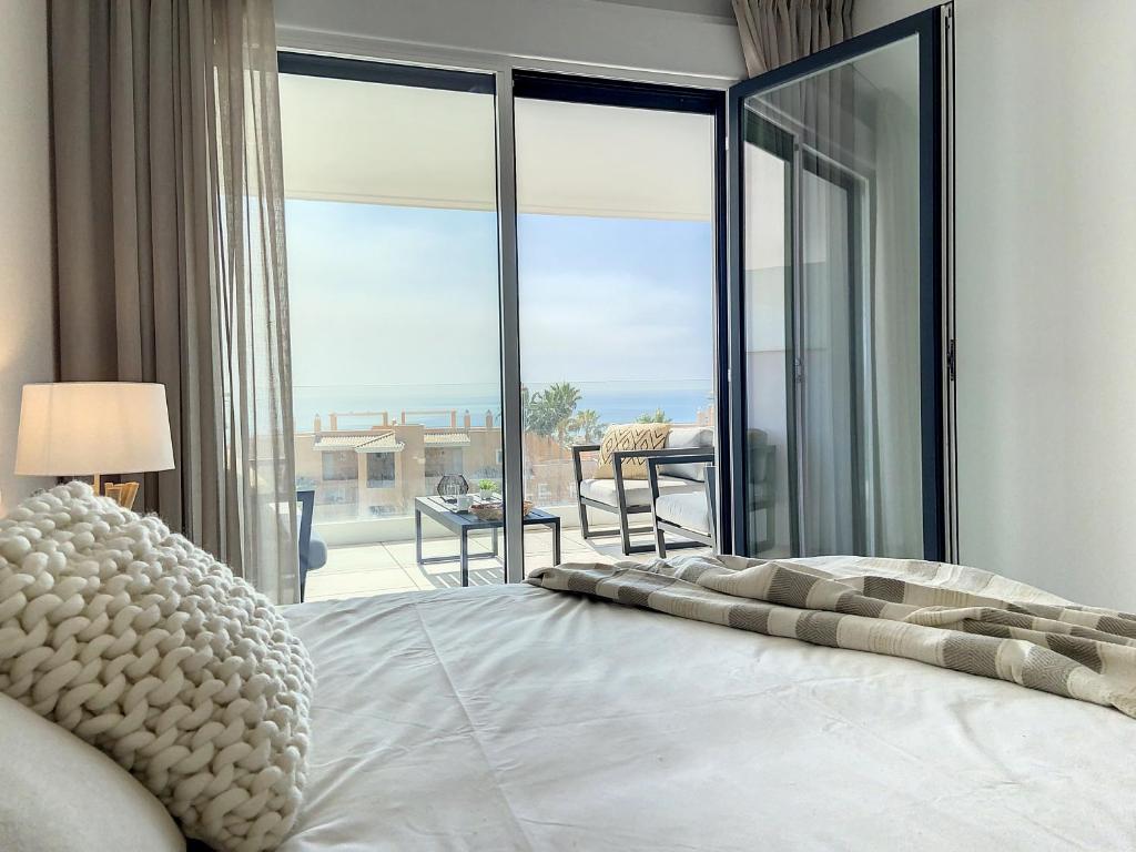 sypialnia z łóżkiem i widokiem na balkon w obiekcie Via Celere 2330 Sea View Apartment w mieście Casares