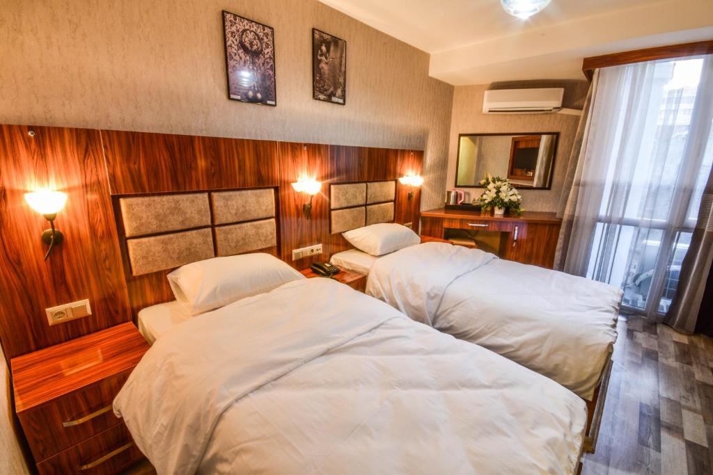a hotel room with two beds and a window at MARİNA HOTEL in Izmir
