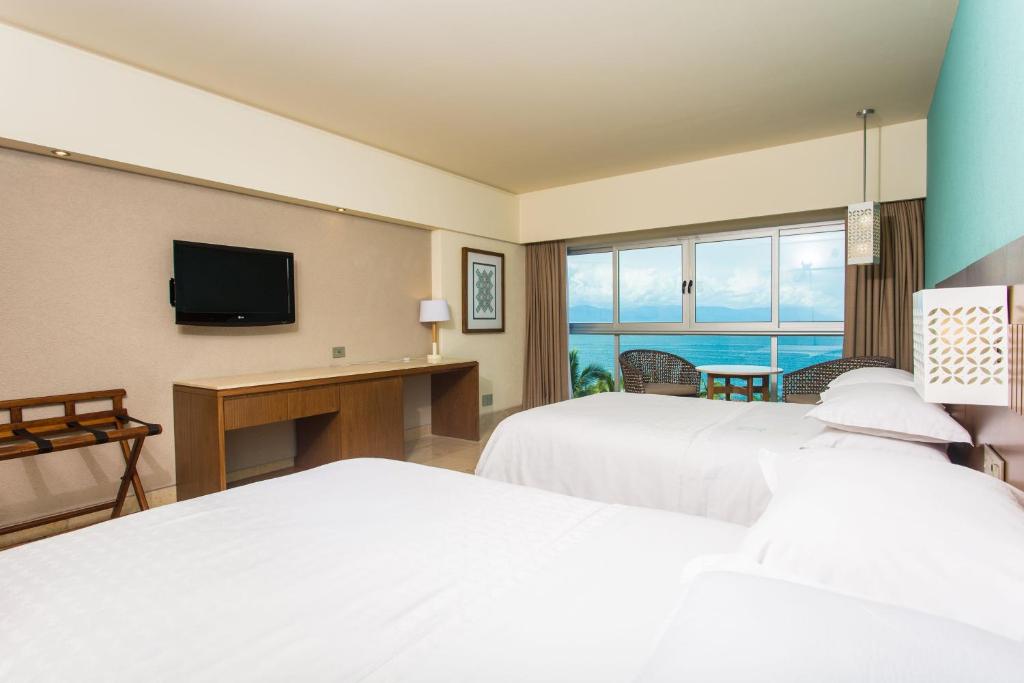 Voodi või voodid majutusasutuse Sheraton Buganvilias Resort & Convention Center toas