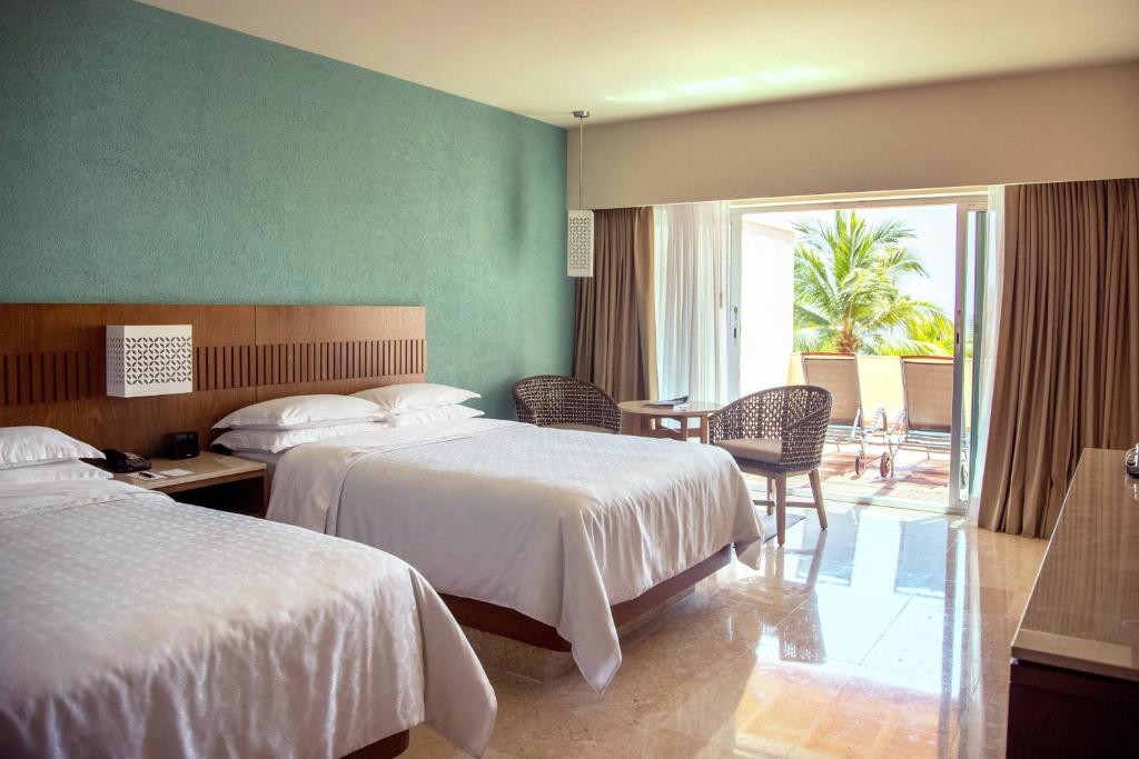 Voodi või voodid majutusasutuse Sheraton Buganvilias Resort & Convention Center toas