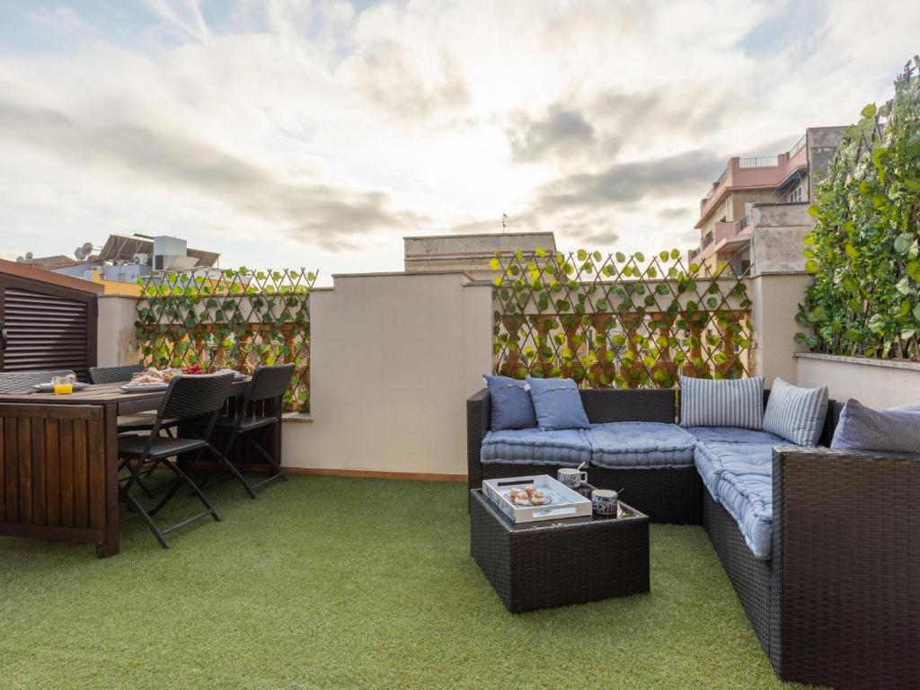 a rooftop patio with a couch and a table at Matarolux23 in Mataró