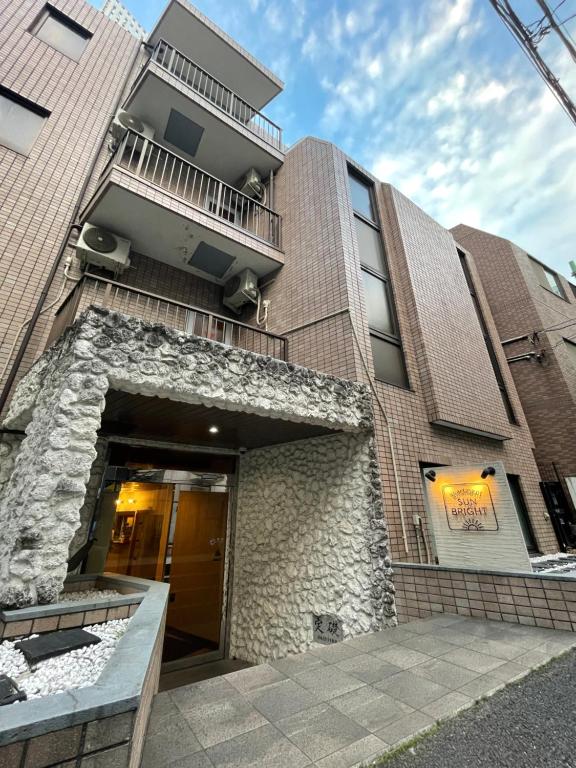 a brick building with a door and a balcony at Apartment Sunbright in Tokyo