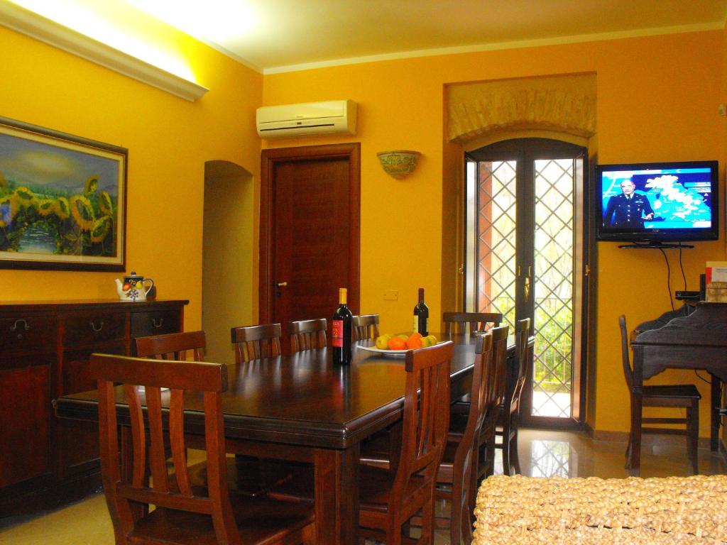 a dining room with a table and a television at Il casello della scala dei turchi in Realmonte