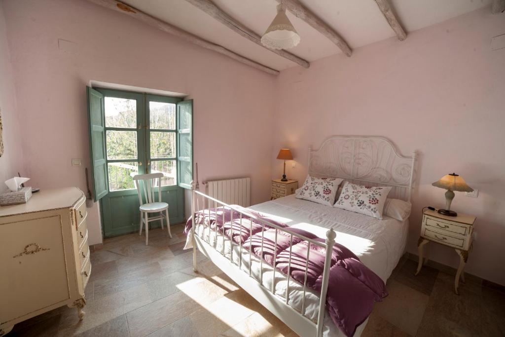a bedroom with a white bed and a window at Cortijo Privilegio in Lanjarón